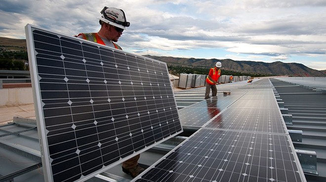 Workers conduct a solar panel installation project.