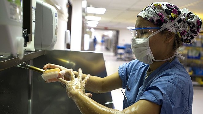 A surgical technician scrubs in before entering an operating room at Lackland's Wilford Hall medical facility.