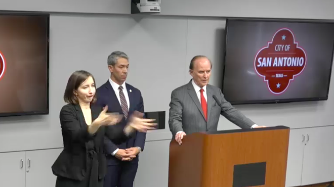 Bexar County Judge Nelson Wolff addresses the press while a sign language interpreter translates.