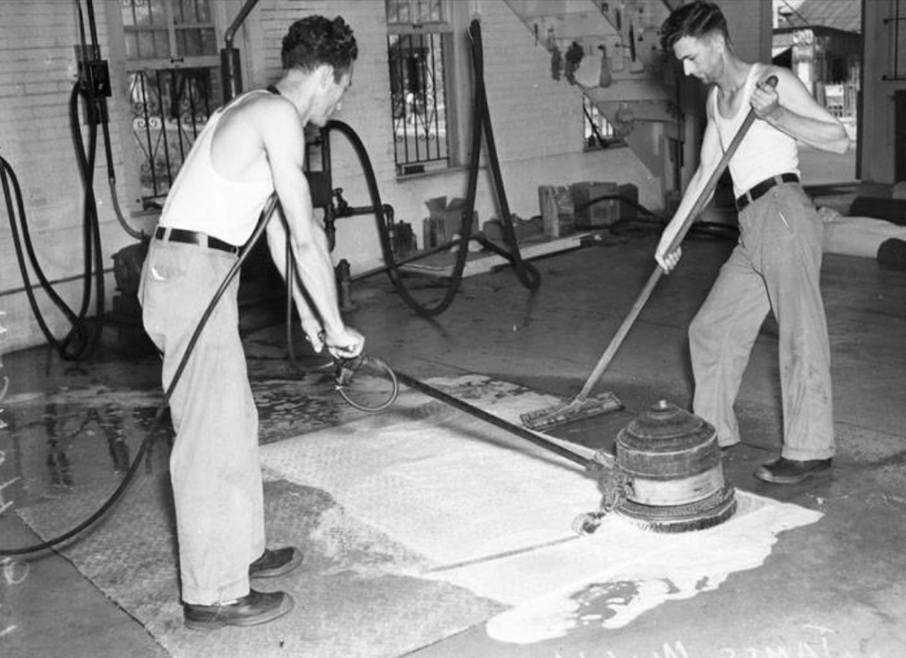 This 1939 photo shows L.G. Hansen and James Walker scrubbing carpet with a huge revolving brush. Hansen owned his own business dedicated to cleaning rugs.