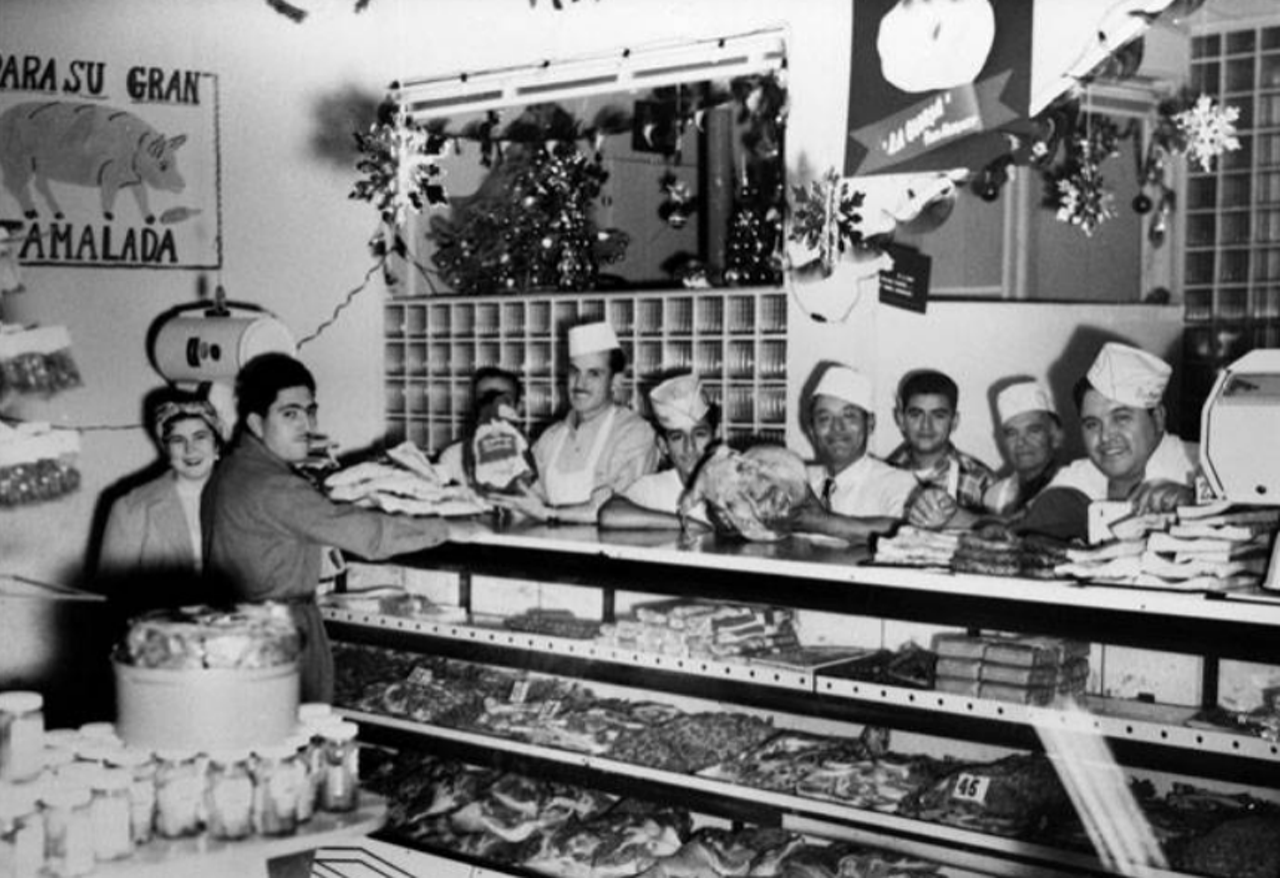 The tamaladas back in the '50s must have been poppin'. Here you can see meat counter workers at La Gloria Food Market.