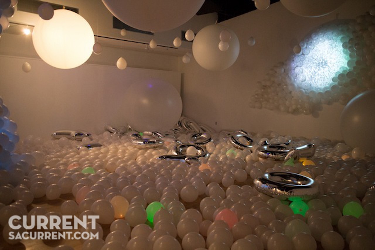 No longer on view, but meriting mention, was an installation by artist collective The Lullwood Group. Glowing balloons filled the floor, lit weather balloons hung down, projected colored light mixed with all, while the collective&#146;s members clad in white uniforms like demented lab techs walked about the crowd welding balloons shaped like tires colored in Warhol silver. Photo: Chris Castillo