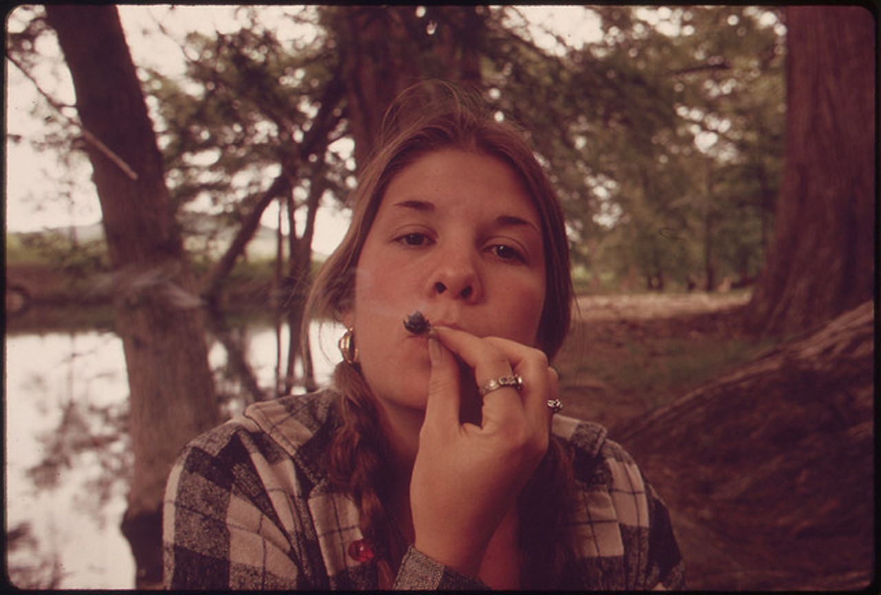 Teenage Girl Smoking Pot in Cedar Woods While on an Outing with Friends near Leakey, Texas.