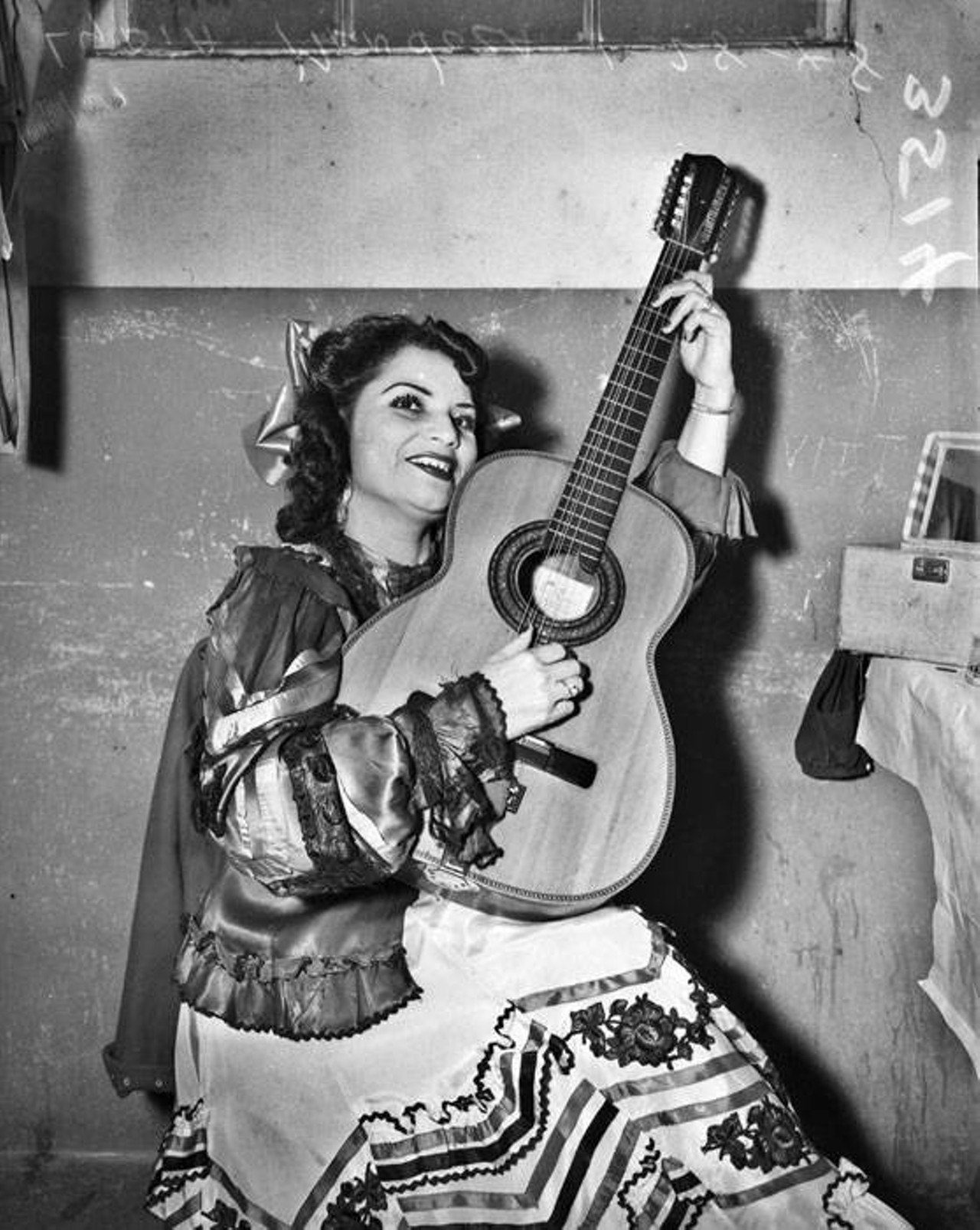 Lydia Mendoza
Singer, guitarrista and border babe, Lydia Mendoza was an early female Mexican-American music icon of her time. She learned to sing and play the guitar from the matriarchs of her family (so girl power!) and soon performed with the family band even though she was just a little girl. Over her lifetime, she would receive numerous awards for art, culture, and heritage. She passed away at the ripe old age of 91, most likely of plain old age, and is buried at the San Fernando Cemetery right here in San Antonio. Basically, she was a legend.
Photo via UTSA Libraries Digital Collections