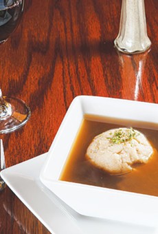 A single dumpling floats atop an honest bouillon soup.