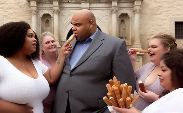 Charles Barkley bites into a churro in front of the Alamo.