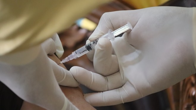 A medical professional provides a vaccine injection.