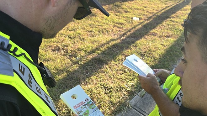 Workers with the Bexar County Office of Emergency Management prepare to distribute door hangers with information on avoiding mosquito-borne diseases.