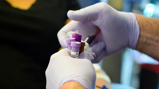 A technician handles vials of blood during a donation drive.