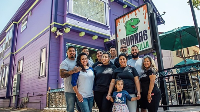 Members of the family that owns Iguanas Burritozilla pose in front of one of their eateries.