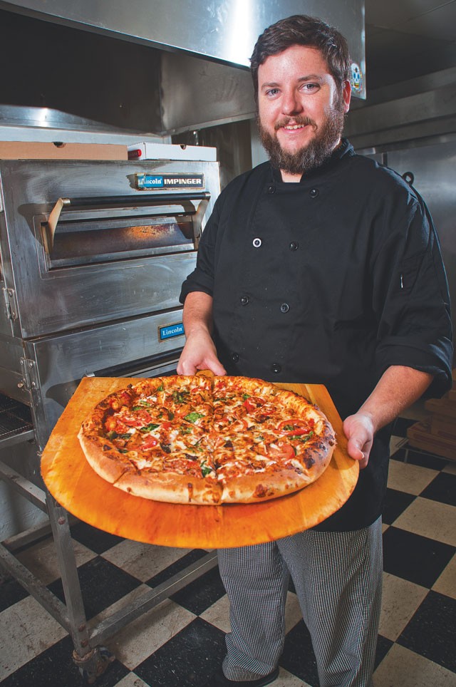 Co-owner Jeremiah McMillan presents a hot, fresh Gallo pizza. - Erik Gustafson