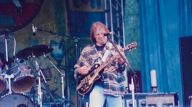 Neil Young performs onstage 25 years after the release of his 1971 breakthrough Harvest.