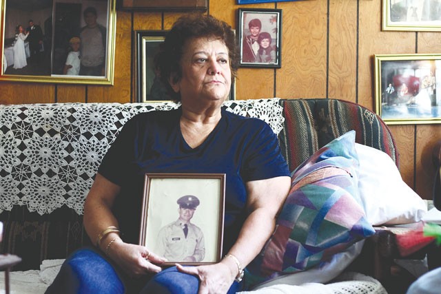 Decades of struggle: Diana Quintanilla Montoya holds a photo of her husband. - MICHAEL BARAJAS