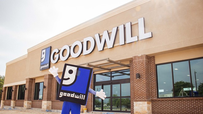 The Goodwill mascot stands outside a newly constructed store.