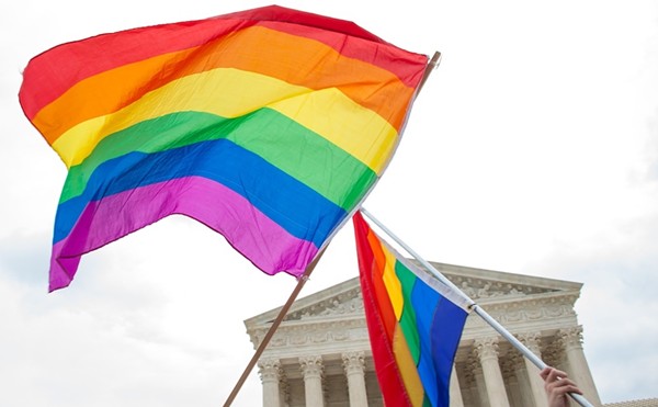People wave Pride flags wave in front of the U.S. Supreme Court building.