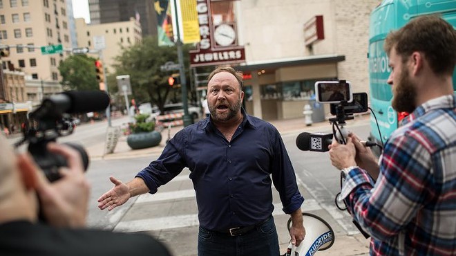 Texas conspiracy theorist Alex Jones records a video for his Infowars show on a street corner in downtown Austin in 2018. While bankruptcy filings for three of his companies earlier this month may be part of his legal strategy to obstruct court proceedings in defamation cases that he has lost, they’re also the latest development in Jones’ downswing from his spot at the top of far-right media.