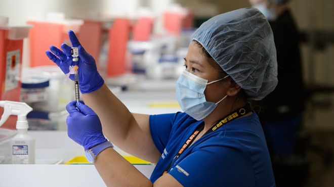 A health worker prepares a syringe at a San Antonio vaccination clinic.
