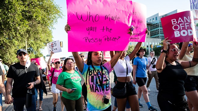 Abortion-rights protesters carry signs through downtown San Antonio on Friday.