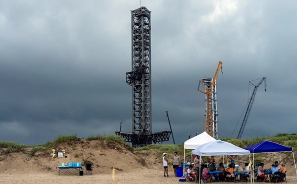 Space X rocket launch platforms loom over members of the ENTRE Film Center gathered to celebrate and preserve Boca Chica Beach near Brownsville on Aug. 31.