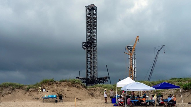 Space X rocket launch platforms loom over members of the ENTRE Film Center gathered to celebrate and preserve Boca Chica Beach near Brownsville on Aug. 31.