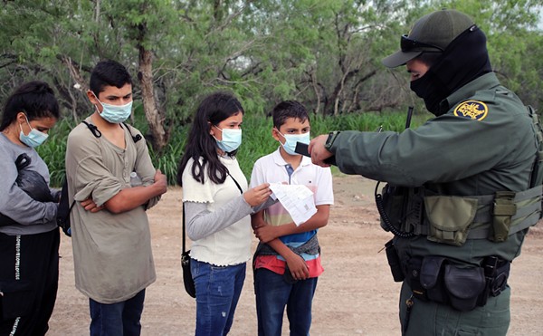 A Border Patrol agent processes a group of unaccompanied Central American minors who crossed the Rio Grande River.