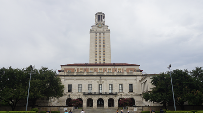 Students walk toward the Main Building on the campus of the University of Texas at Austin.