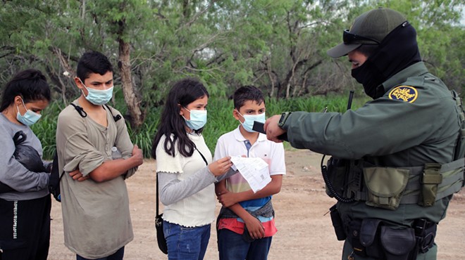 A Border Patrol agent processes a group of unaccompanied Central American minors who crossed the Rio Grande River.