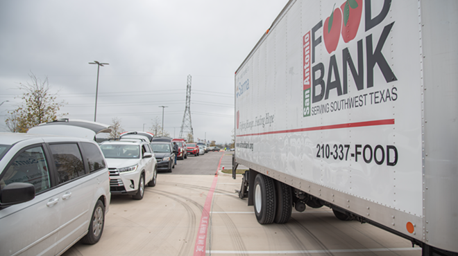 A line of cars wait to receive food from the San Antonio Food Bank