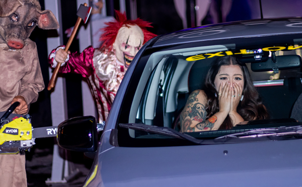 A clown and a chainsaw-wielding pig scare patrons as they go through the the Super Sudz Car Wash haunted tunnel.