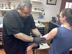 Orlando-based tattoo artist Rick Rosas transfers an image on a client at Los Muertos Tattoo Company in the Medical Center. Rosas was left without a place to work when the final day of the Texas Tattoo Jam was cancelled after promoter Renee "Red" Neilson failed to pay the San Antonio Event Center for renting the venue. Los Muertos owner Lupe Diaz Jr. opened his shop to Rosas to help him recoup some of his losses. - Kiko Martinez