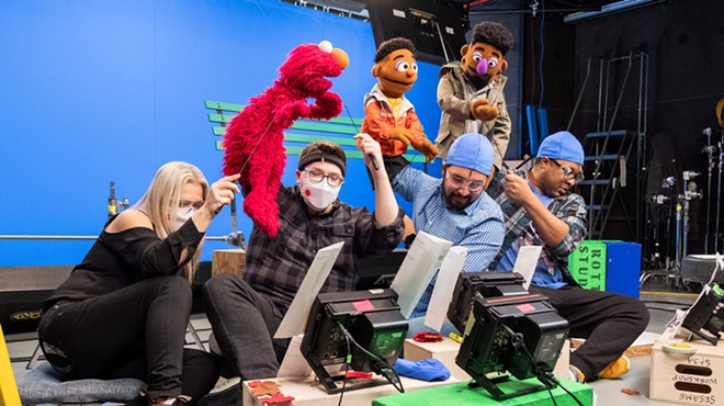 Bradley Freeman Jr. (second from right) controls the  Wesley Walker Muppet during a shoot for a Sesame Street online series.