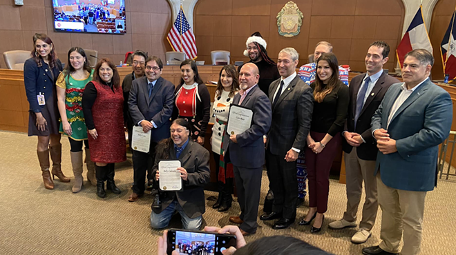 Retiring Express-News photographers strike a pose with City Council after being honored by District 4's Adriana Rocha Garcia.