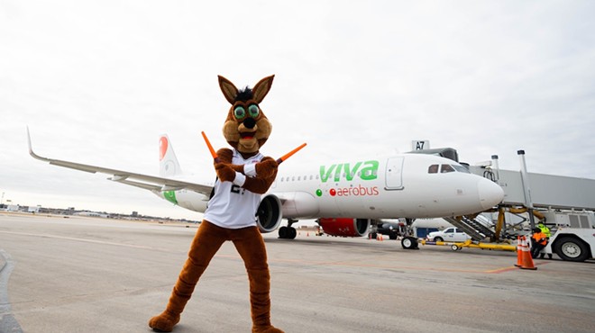 The Spurs Coyote pretends (we hope) to direct ground traffic at a San Antonio International Airport press event.