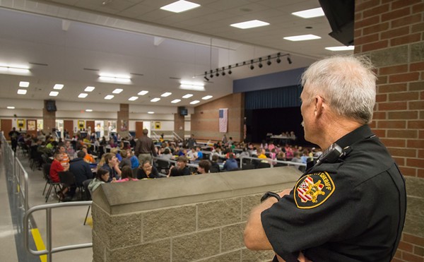 A security guard at an Ohio school looks out over students in the cafeteria at lunch time.