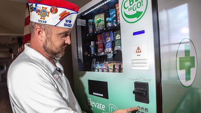 Dave Walden, wearing a Veterans of Foreign Wars cap, demonstrates how the CBD vending machine works by purchasing a product in Leander on Nov. 1. Credit: Azul Sordo/The Texas Tribune