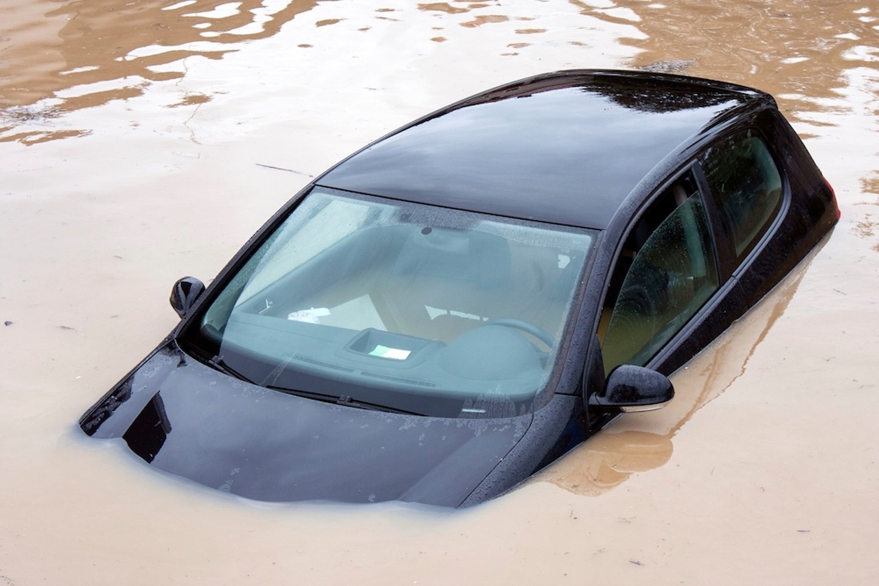 Olmos Park Terrace: A car mostly submerged in floodwaters. 
Millions of dollars in floodwater projects later, we’re still drowning.