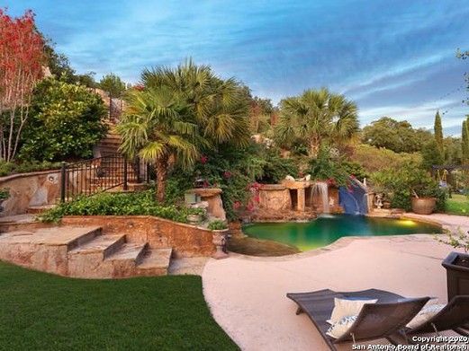 The waterfall-fed pool of this $1.9 million San Antonio mansion looks like a tropical lagoon
