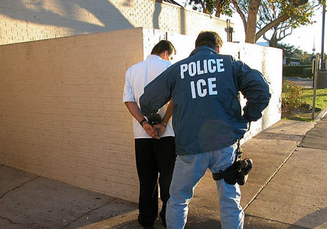 An ICE agent detains a suspect. - Wikimedia Commons