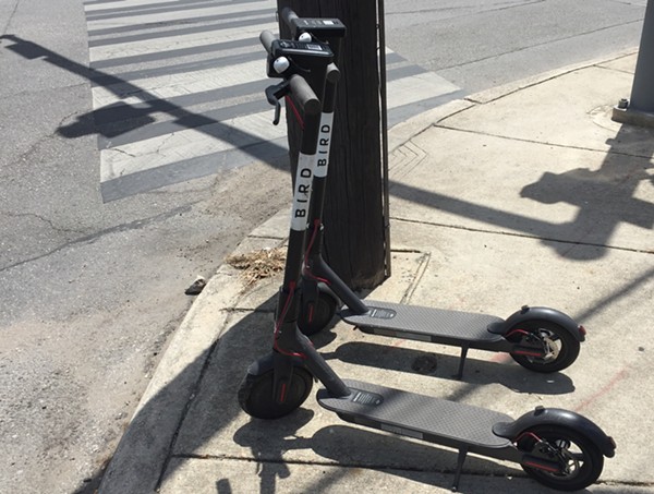 A pair of dockless scooters sit on a sidewalk along North St. Mary's Street. - Sanford Nowlin