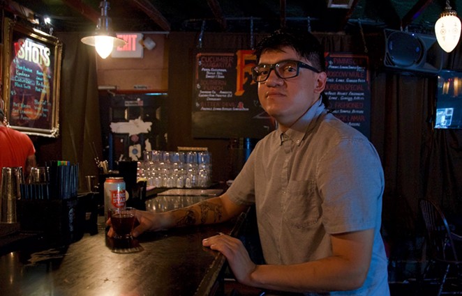 Sous chef JC Rodriguez enjoys a drink inside the cool and dark confines of Faust, his favorite local watering hole. - LEA THOMPSON