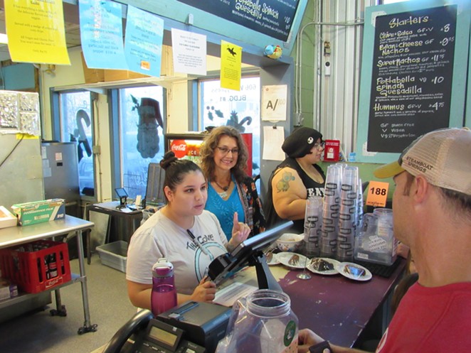 Lisa Asvestas smiles as an employee helps a customer. - SANFORD NOWLIN