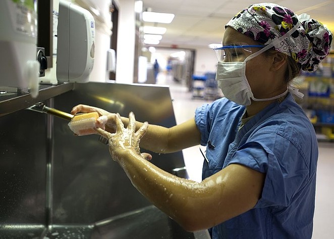A surgical technician scrubs in before entering an operating room at Lackland's Wilford Hall medical facility. - KEVIN IINUMA / WIKIMEDIA COMMONS