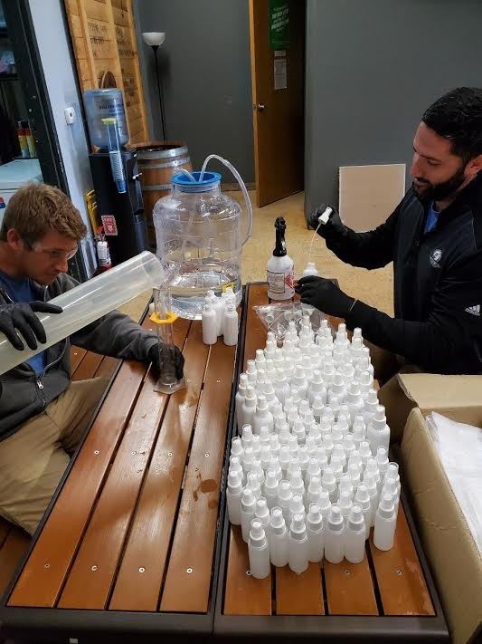 Ranger Creek employees mix up hand sanitizer to package in spray bottles. - Courtesy Photo / Ranger Creek