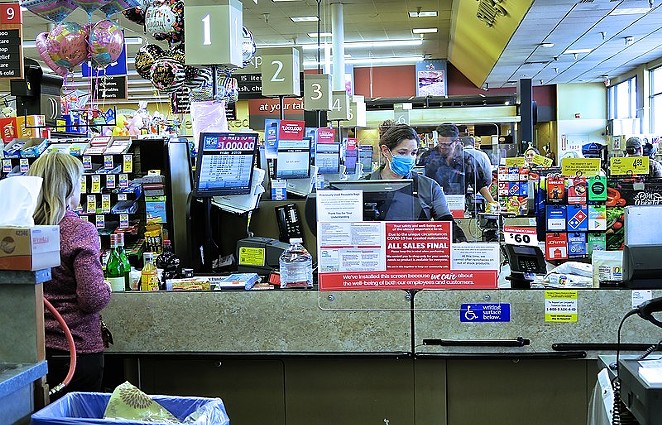 A grocery store checker works in her mask and behind a protective shield. - RUSS ALLISON LOAR / WIKIMEDIA COMMONS