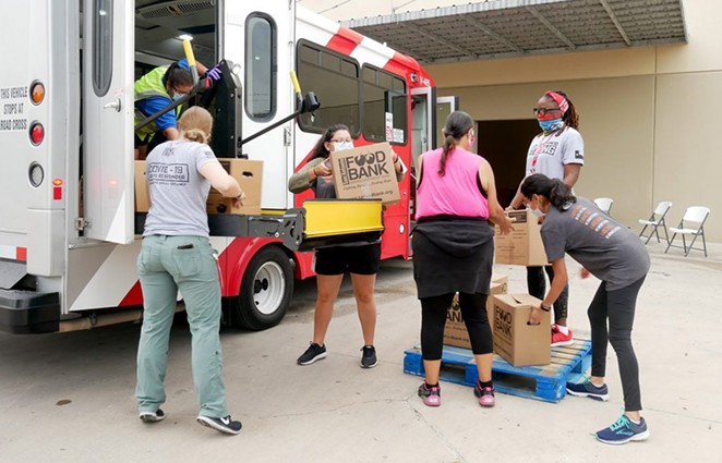 Volunteers load a bus with food on June 26.