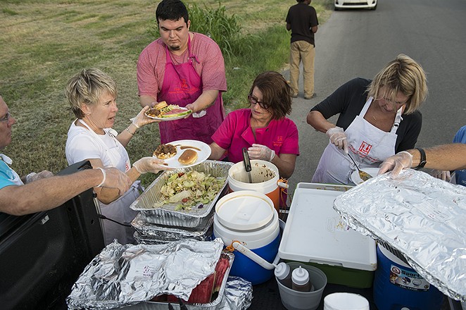Joan Cheever (center) and her volunteers plate meals on Tuesday, July 7. - CARLOS SANCHEZ
