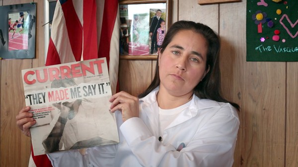 A still from the documentary film Southwest of Salem of Anna Vasquez holding a 2012 issue of the San Antonio Current featuring a cover story about the case of the San Antonio Four. - Motto Pictures and Naked Edge Films