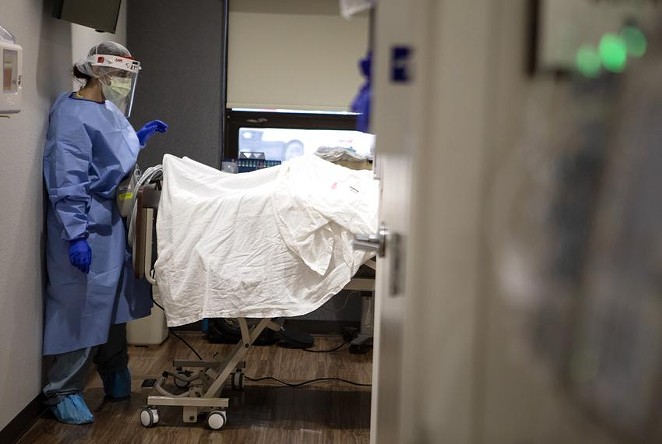 A nurse visited a COVID-19 patient last summer at an Edinburg hospital. Dozens of facilities have reported that their ICUs have been at or above 100% capacity for weeks, leaving staff overworked and stretched thin. - MIGUEL GUTIERREZ JR. / THE TEXAS TRIBUNE