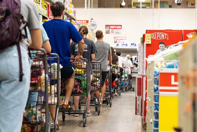 Grocery shoppers formed a long line at the H-E-B grocery store at Hancock Center in Austin last year. Grocery store employees were called essential when the pandemic began, but haven't been given priority access to the coronavirus vaccine. - Texas Tribune / Jordan Vonderhaar