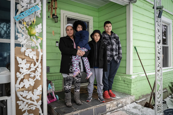 Marleny Almendarez, 38, with her niece Madelyne Hernandez, 3, and two boys, Aaron Hall, 11, and Matthew Hall, 14, outside their home in Dallas on Feb. 18, 2021. The family spent two nights at a mobile warming station to avoid the cold temperatures. - BEN TORRES FOR THE TEXAS TRIBUNE